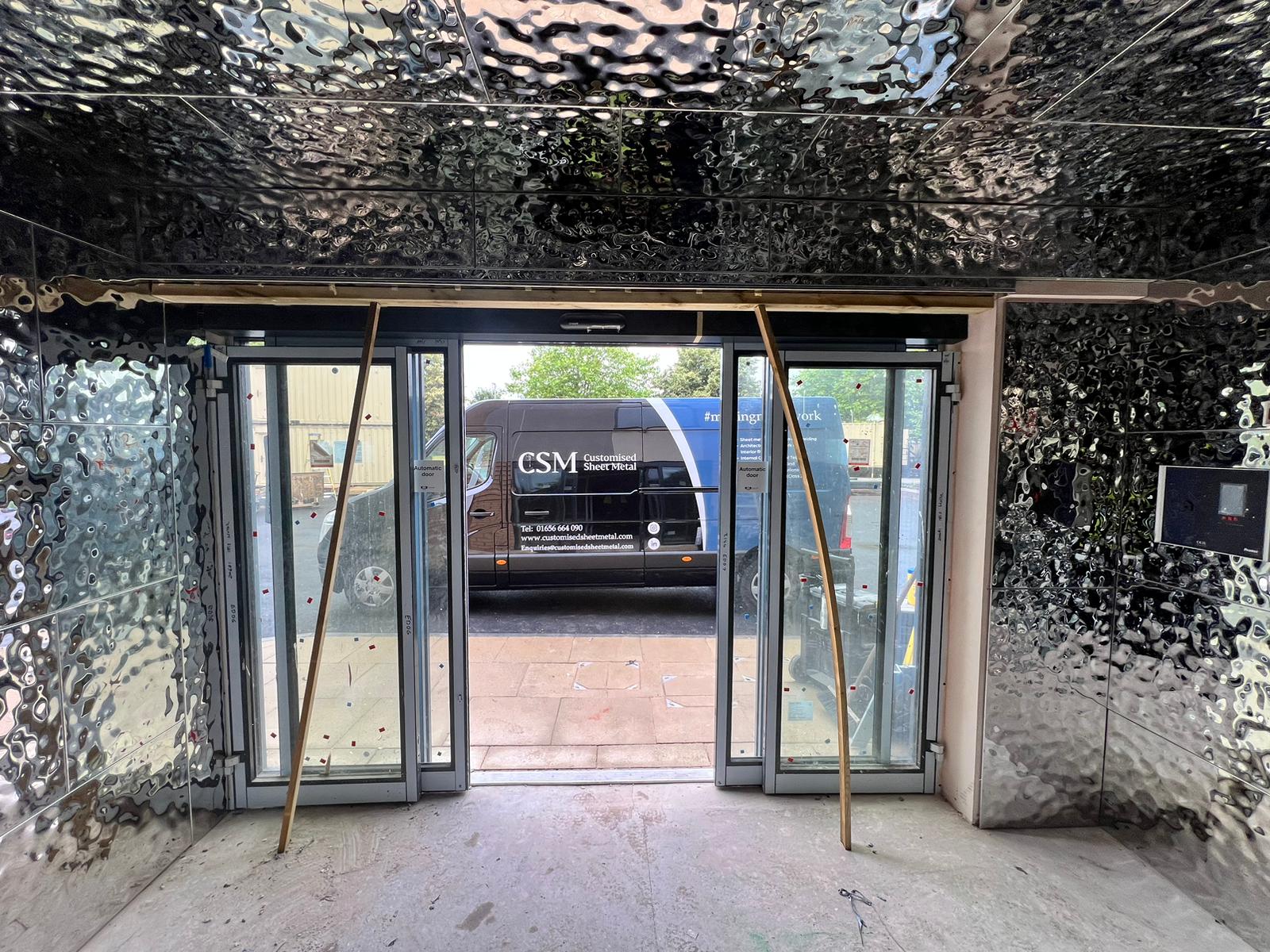 Bespoke wall cladding installed on site, with a CSM van outside