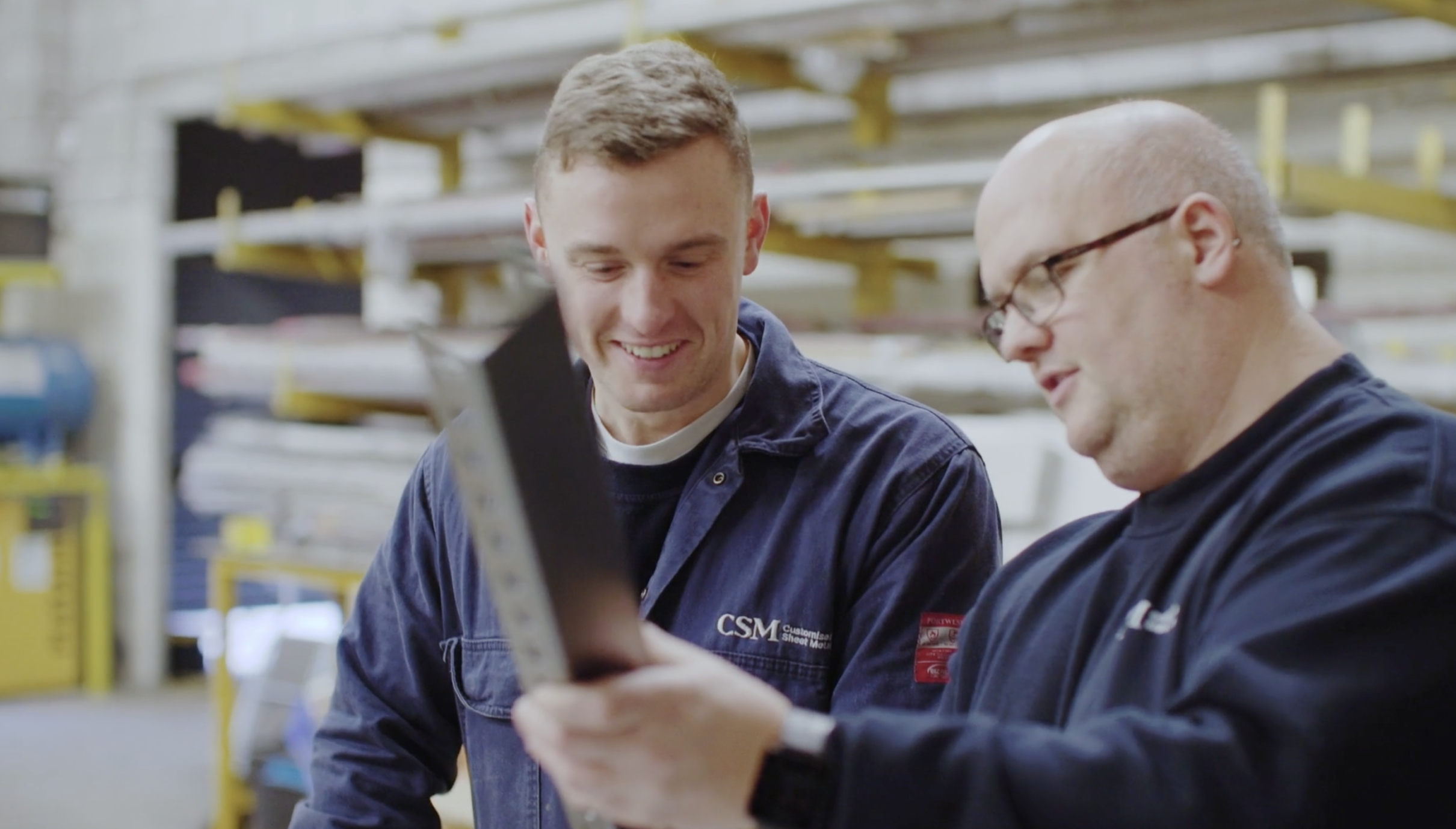 Two CSM fabricators reviewing a piece of finished metalwork