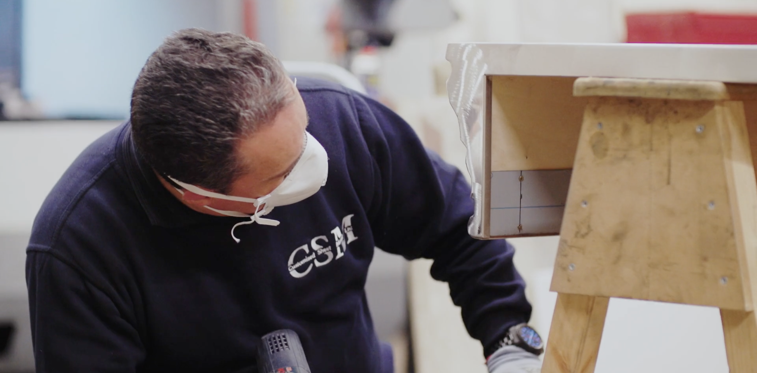 CSM fabricator checking a finished sheet metal part close up